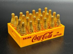 Coca-Cola / Gold Metal Mini Bottles in Yellow Plastic Crate Image